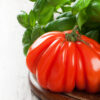 Fresh tomato with basil on old wooden board. Pomodoro Abruzzese a pera semi