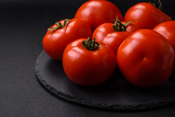 Delicious fresh juicy tomatoes on a dark concrete background Pomodoro Ailsa Craig
